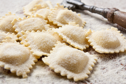 Making homemade ravioli with a wooden roller